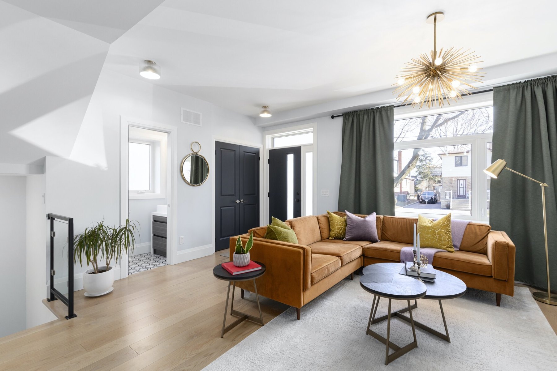 Sunlit living room with warm furnishings and an open kitchen